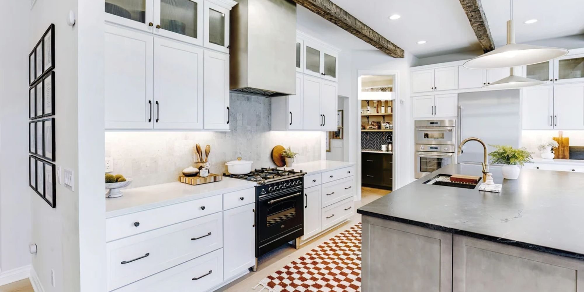 Image of kitchen remodel with white cabinetry, wood beams, and large island in Oakland County, MI by Cabinet Creations