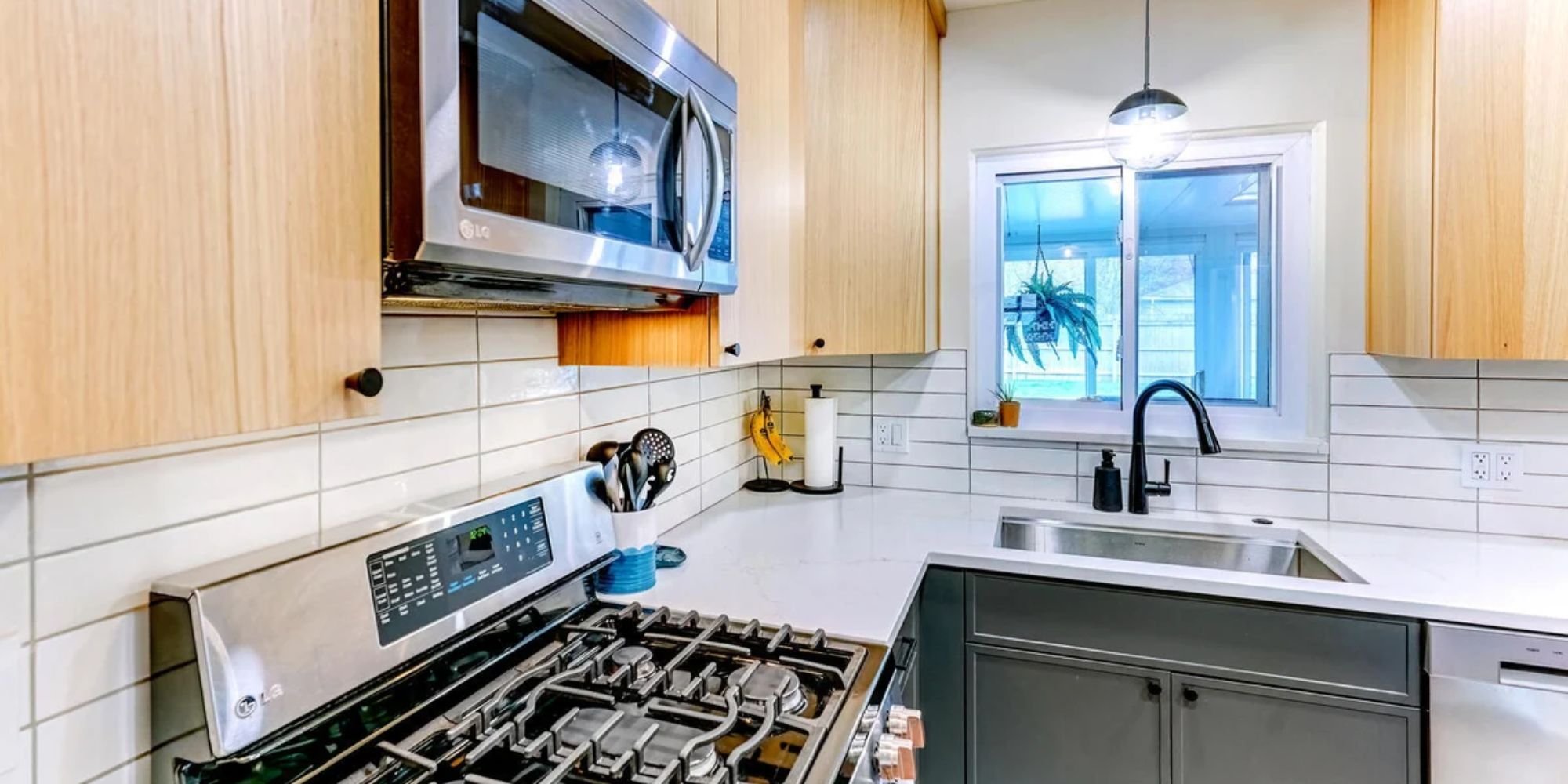 Image of kitchen remodel with wood cabinets, white tile backsplash, and stainless steel appliances in Oakland County, MI by Cabinet Creations