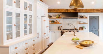 Kitchen remodel with white cabinetry, rose gold hardware, and white stone countertops by Cabinet Creations in Clarkston, Michigan