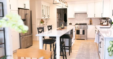 Image of kitchen remodel with modern white cabinetry, bar seating, and subway tile backsplash in Oakland County, MI by Cabinet Creations