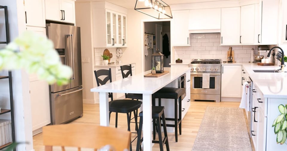 Image of kitchen remodel with white cabinets, island seating, and stainless steel appliances in Oakland County, MI by Cabinet Creations