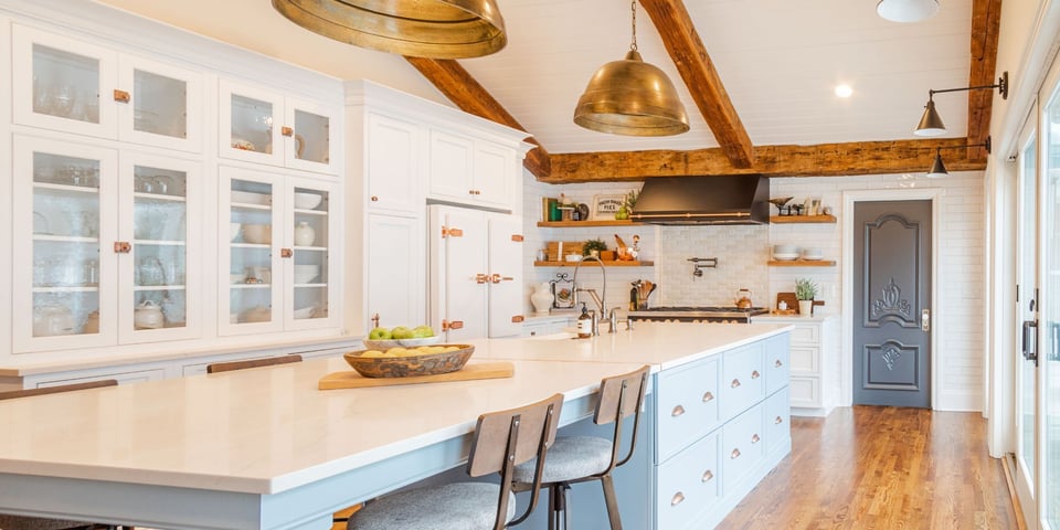 Modern farmhouse kitchen in Oakland County by Cabinet Creations with white cabinetry, copper hardware, and a large island