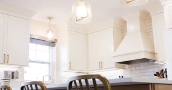 Image of kitchen remodel with bright white cabinetry, modern lighting, and subway tile backsplash in Oakland County, MI by Cabinet Creations