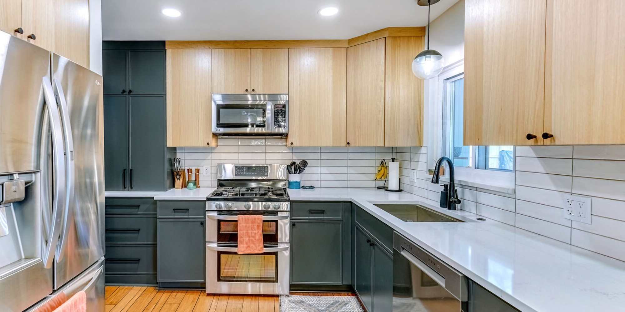 Modern Oakland County kitchen remodel by Cabinet Creations featuring flat-panel wood cabinets and painted lowers