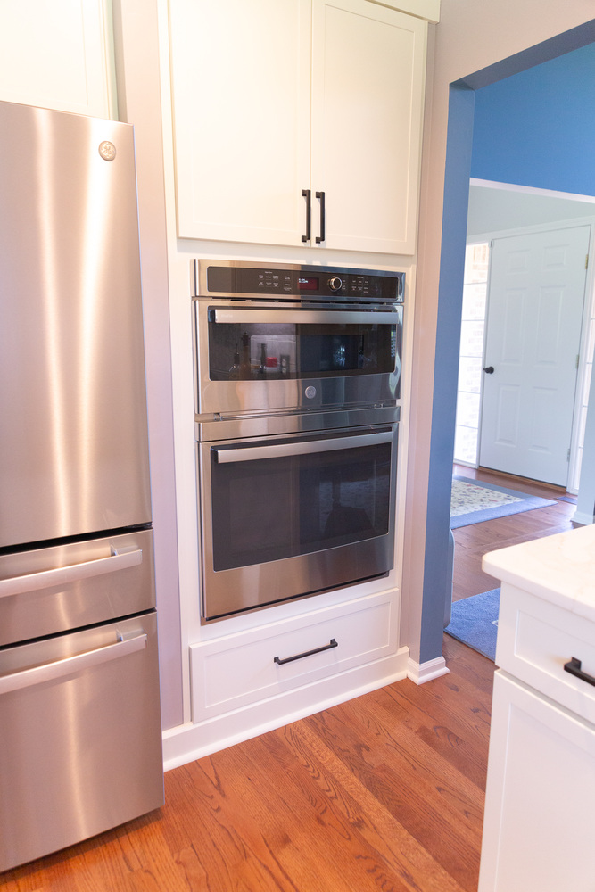 Built-in stainless wall oven and refrigerator in custom kitchen remodel by Cabinet Creations in White Lake, Michigan