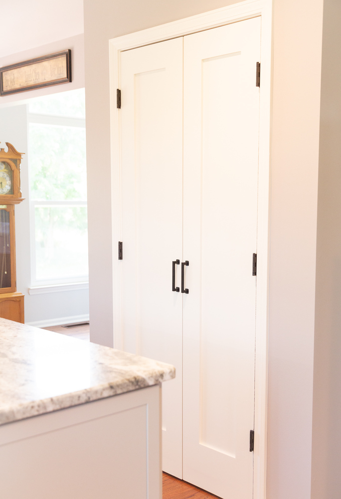 Custom kitchen remodel with white pantry doors and quartz countertop by Cabinet Creations in White Lake, Michigan