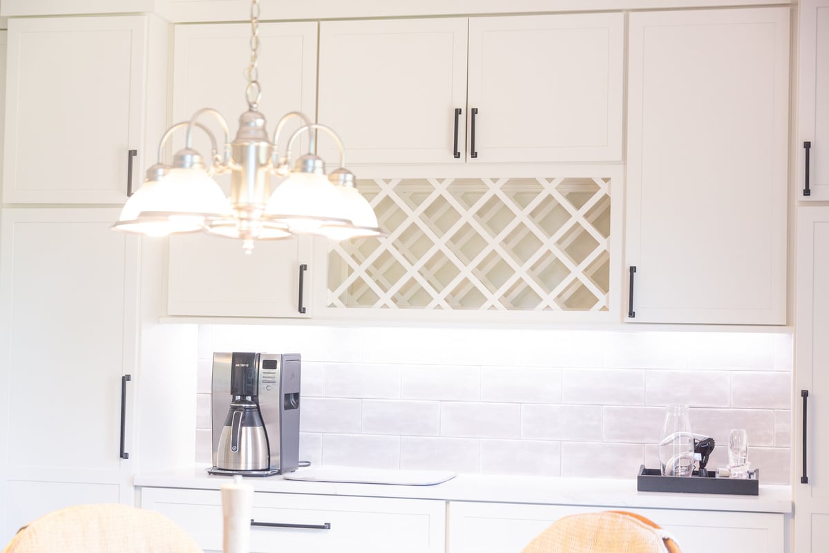 Elegant white cabinets and tiled backsplash in a custom home kitchen by Cabinet Creations in Troy, Michigan