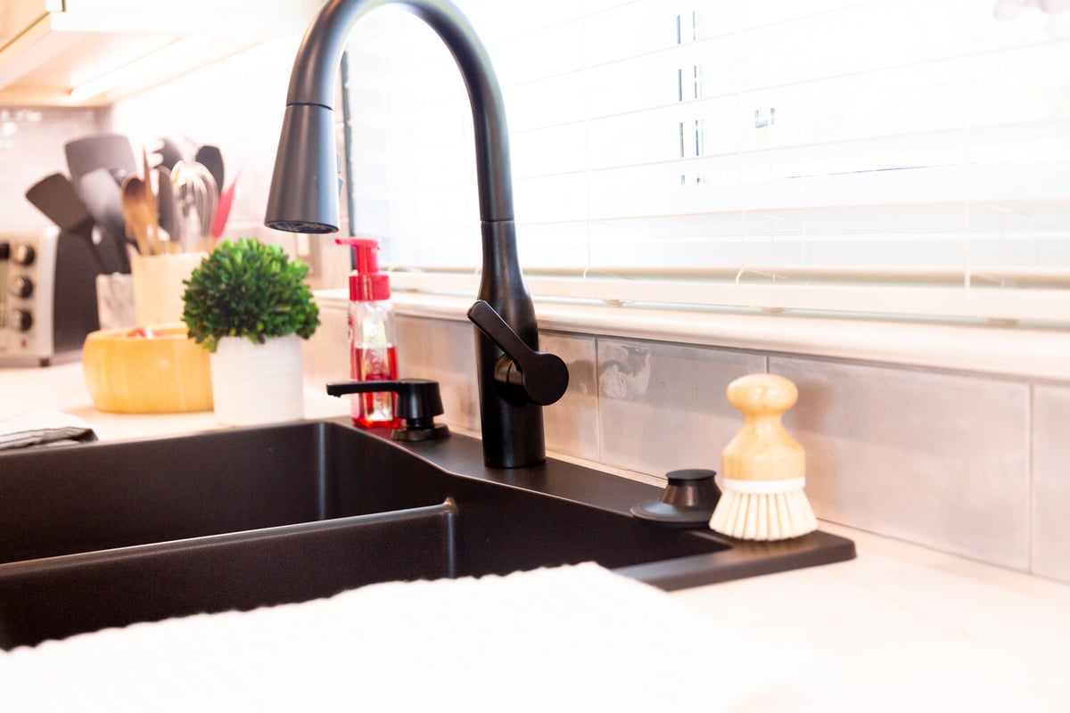Matte black pull-down faucet in a modern white kitchen by Cabinet Creations, West Bloomfield, MI
