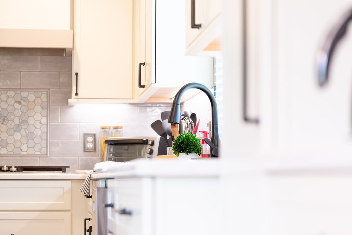 Modern kitchen faucet and sink area with white cabinetry by Cabinet Creations in Bloomfield Hills, MI