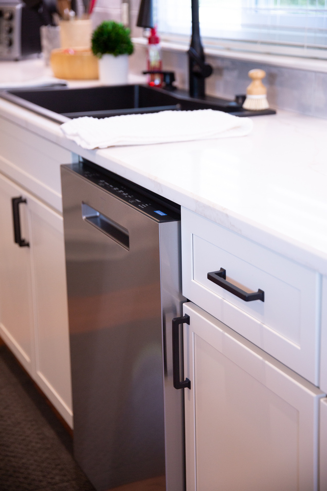 Modern kitchen with stainless appliances and white shaker cabinets by Cabinet Creations in Waterford Township