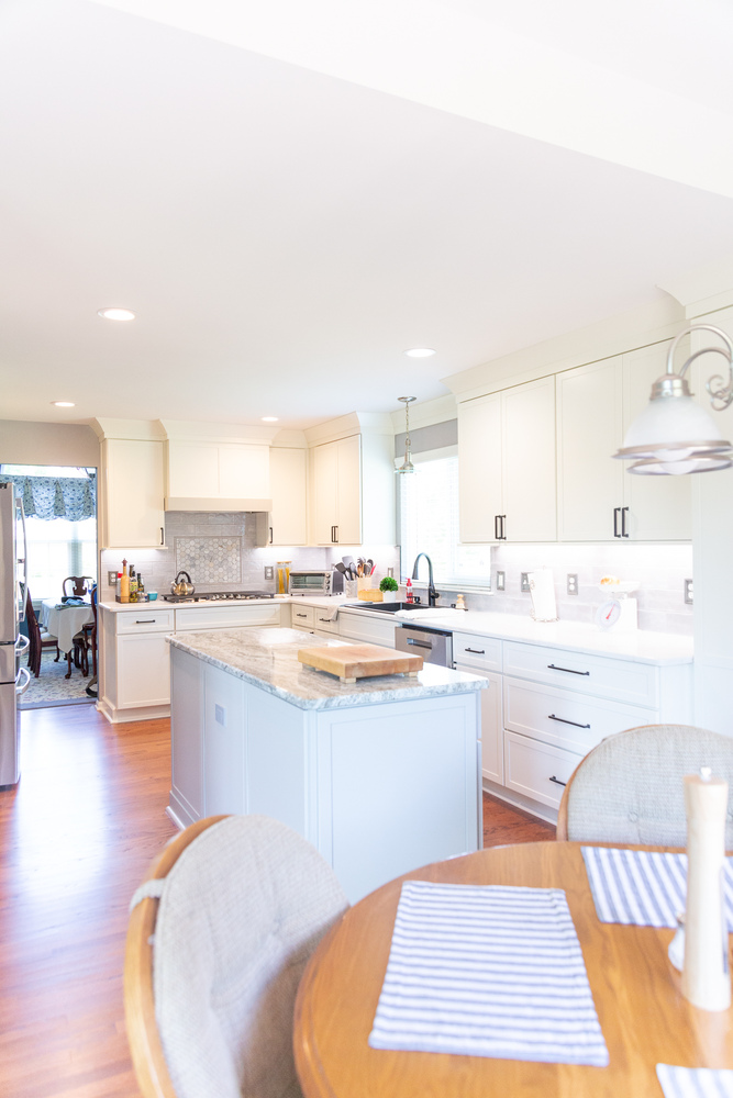 Open kitchen design featuring white cabinets and granite island by Cabinet Creations in Oakland County, MI