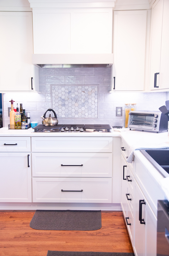 Transitional kitchen design featuring gray backsplash and under-cabinet lighting by Cabinet Creations in Oakland County, MI