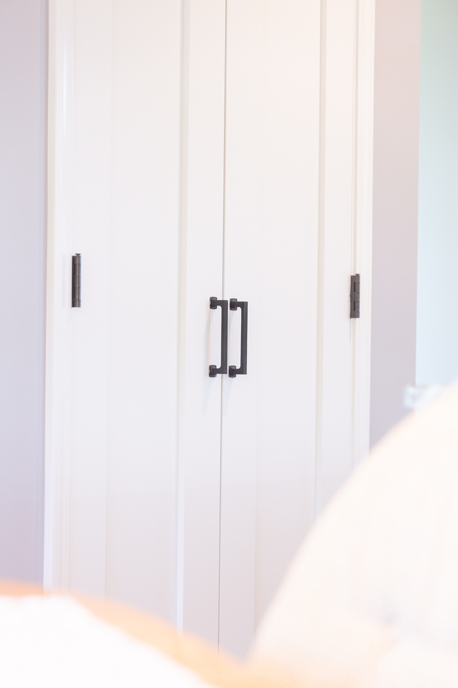 White double pantry doors with black hardware in a custom home by Cabinet Creations in Oakland County, MI