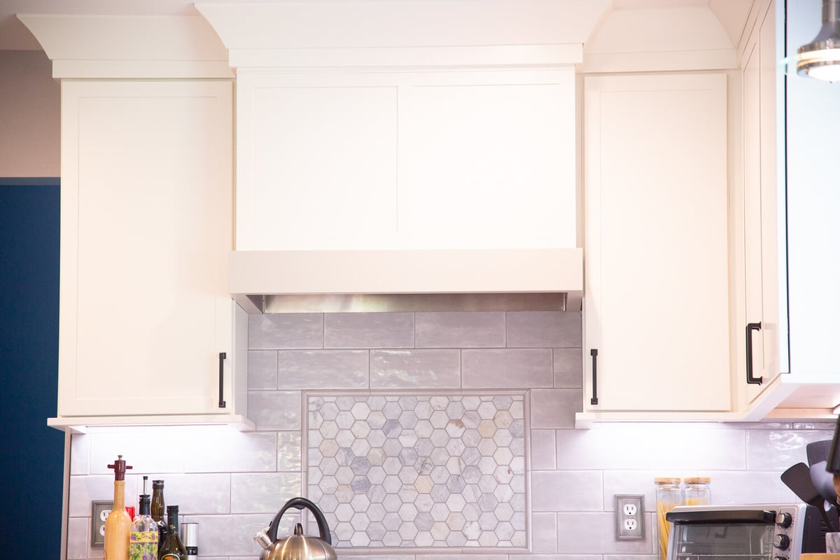 White kitchen cabinetry with crown molding and modern backsplash by Cabinet Creations in Bloomfield Hills, Michigan