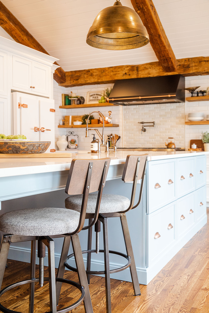 Brass pendant light above kitchen island in a custom Michigan home by Cabinet Creations