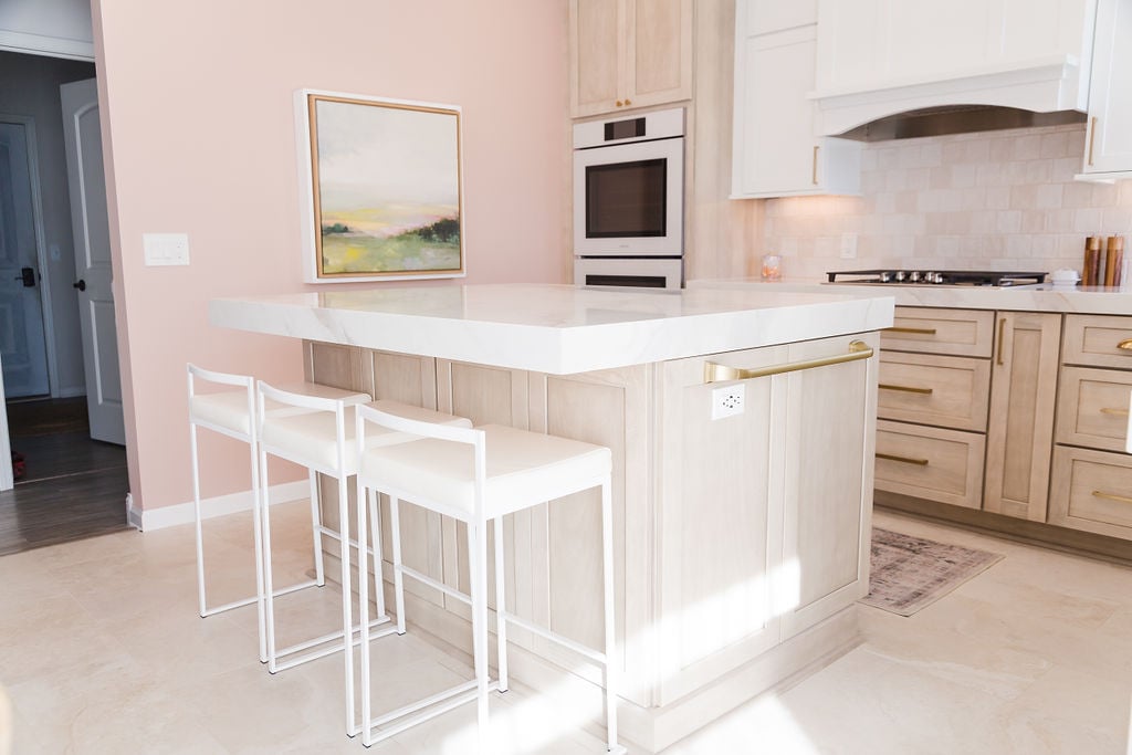 Bright kitchen remodel featuring a large island and gold fixtures in a Michigan custom home