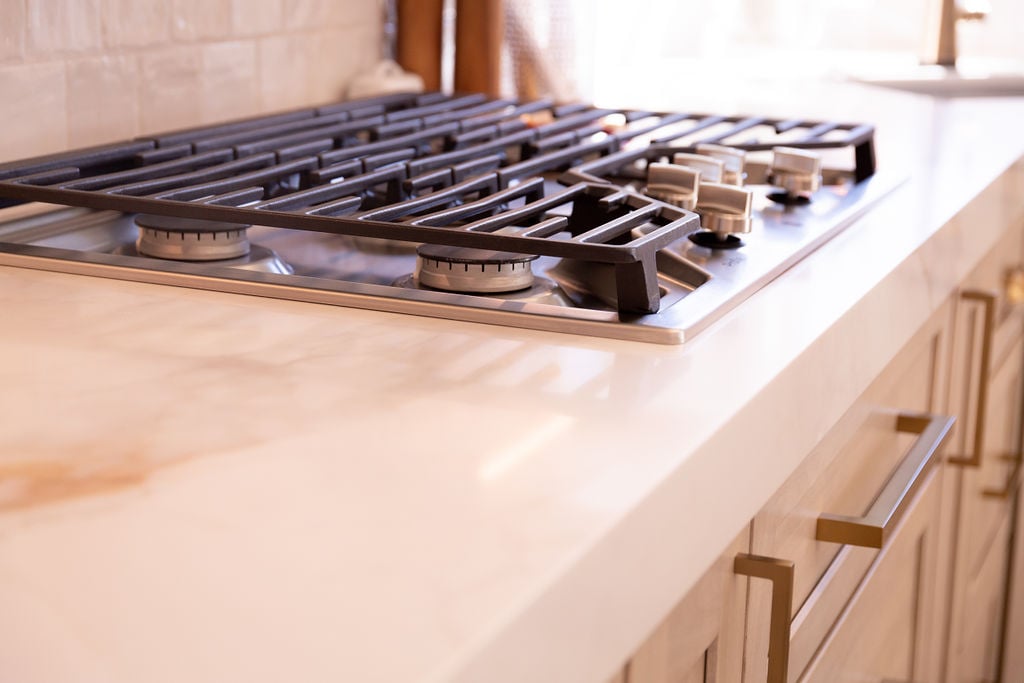 Close-up of gas cooktop on marble countertop by Cabinet Creations, Oakland County, MI