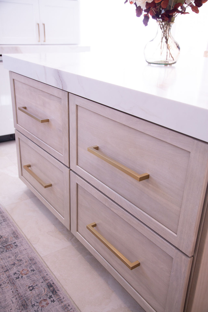 Close-up of kitchen island with white quartz countertop and gold hardware by Cabinet Creations in Oakland County, MI