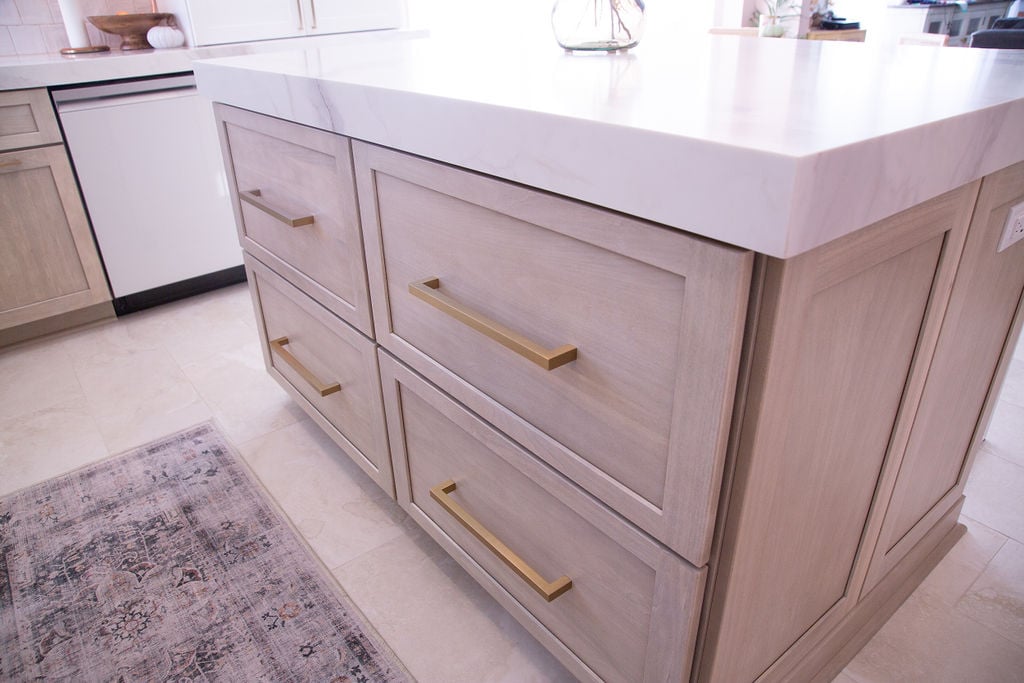 Kitchen island drawers with gold handles and light wood finish by Cabinet Creations in Oakland County, MI