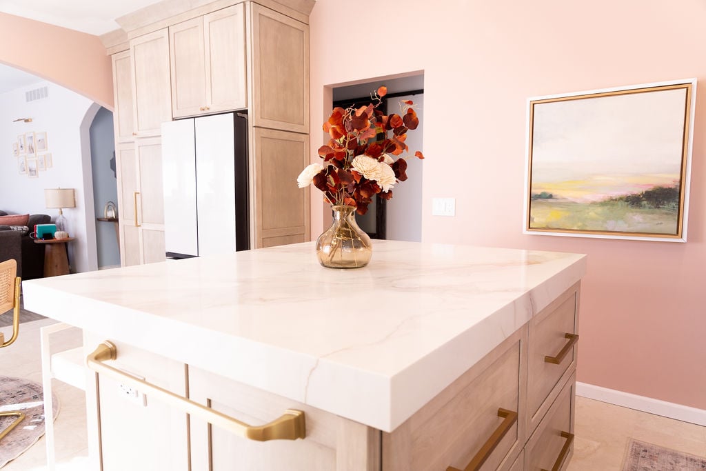 Marble kitchen island with vase centerpiece and light wood cabinetry by Cabinet Creations in Oakland County, MI