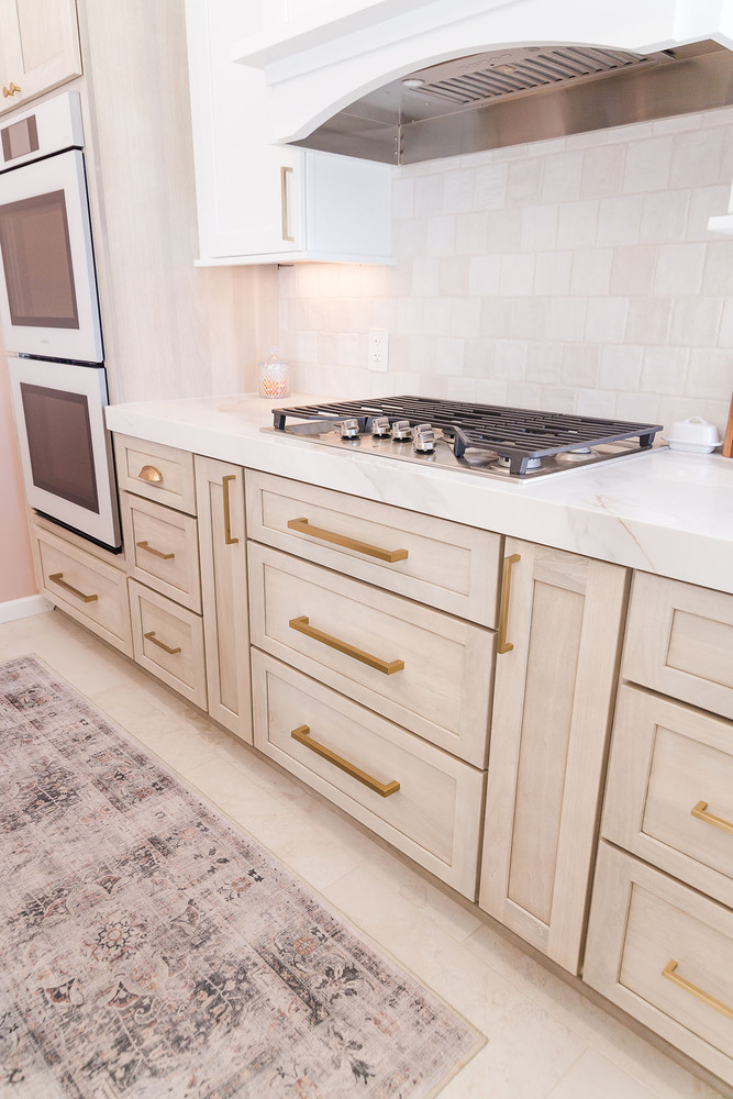 Modern custom kitchen drawers with gold handles and gas cooktop by Cabinet Creations in Waterford Township, MI
