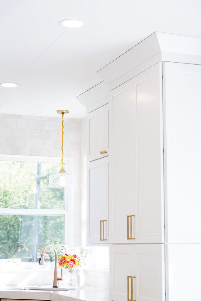 Modern kitchen lighting and tall cabinetry with gold accents by Cabinet Creations, Oakland County, MI