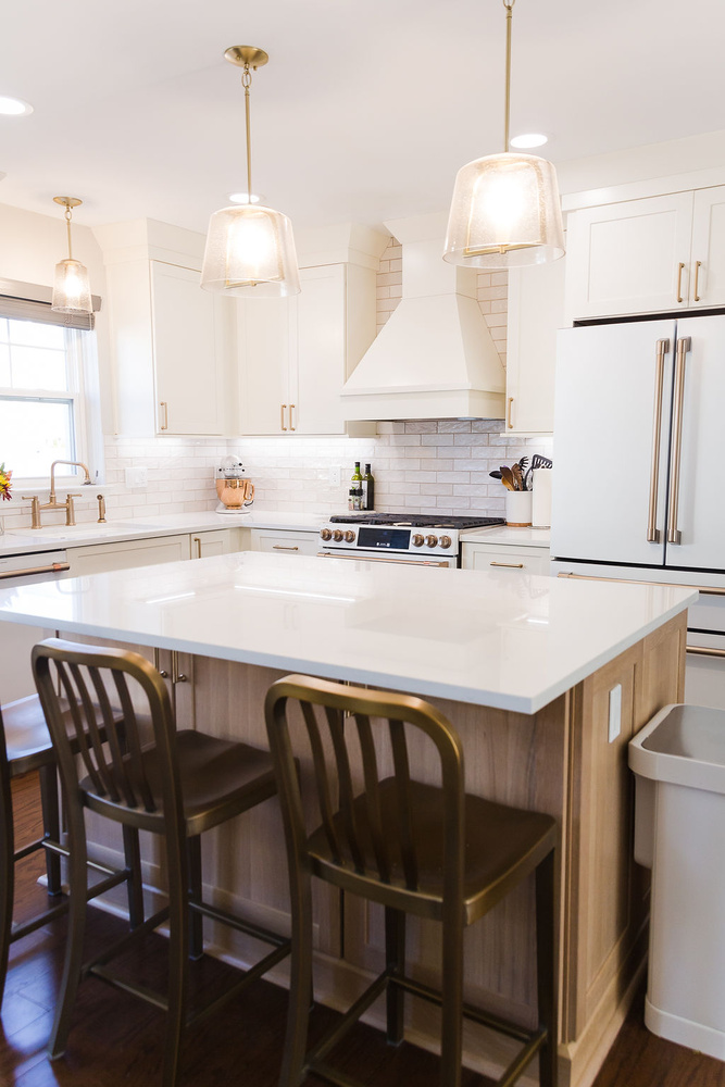 Bright kitchen featuring white cabinetry and large island design in Oakland County, Michigan
