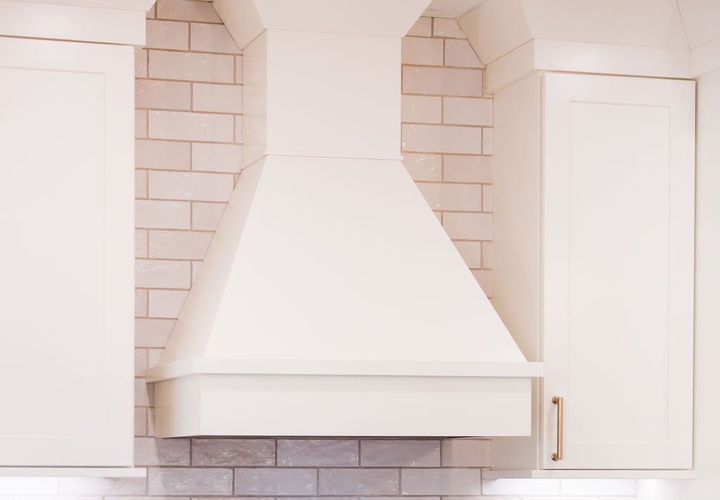Close-up of custom white range hood and tile backsplash by Cabinet Creations in Bloomfield Hills, MI