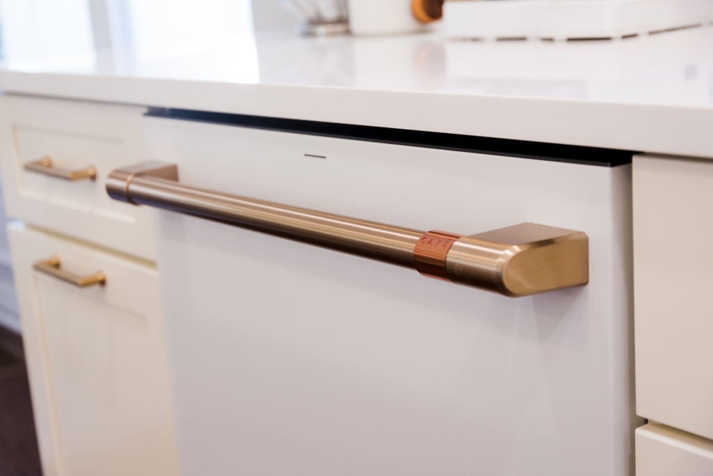 Custom kitchen appliance panel with coordinating brass hardware in Michigan