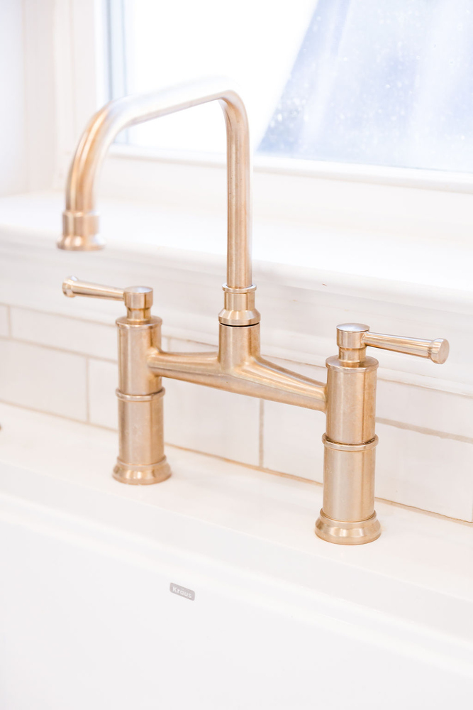 Gold faucet and white tile backsplash design in a Michigan custom home kitchen