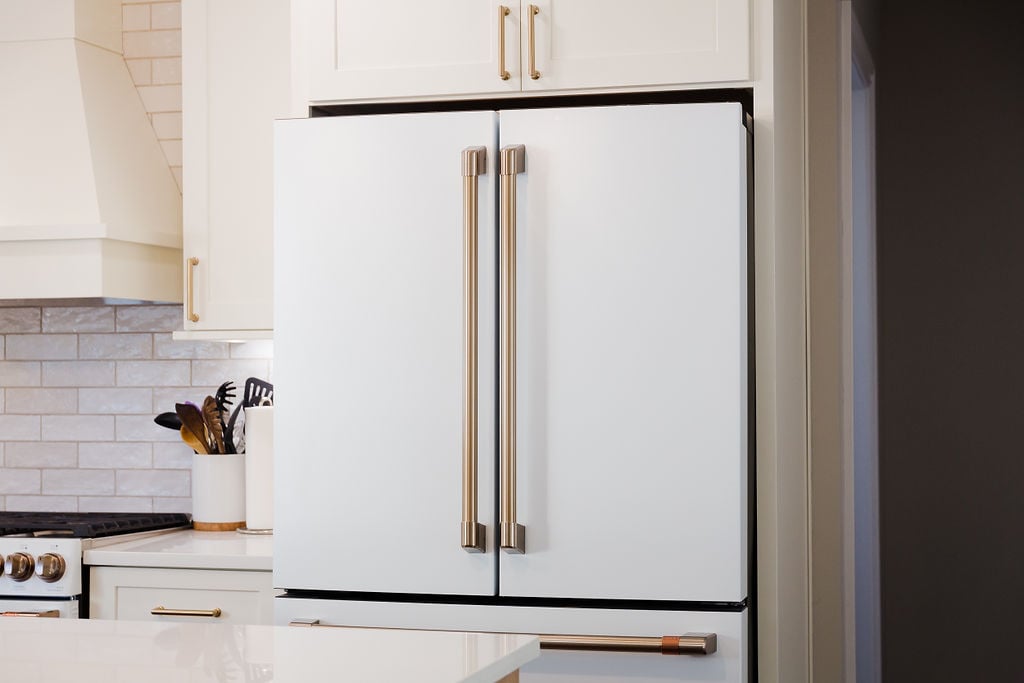 Modern kitchen design featuring sleek white appliances and gold hardware in Michigan