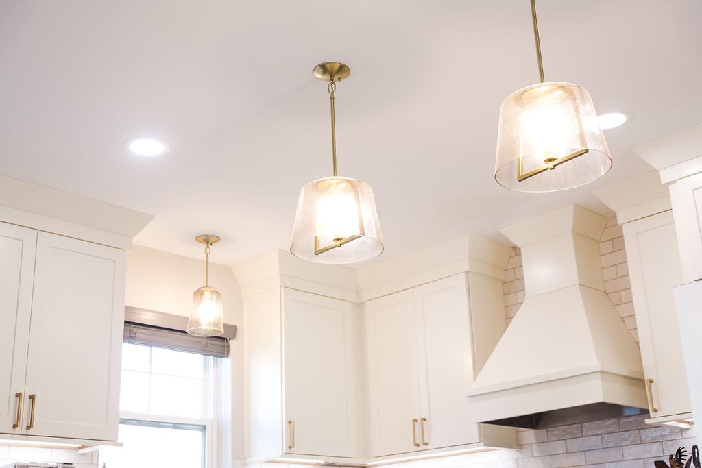 Pendant lighting above white cabinetry in a custom Ferndale kitchen by Cabinet Creations, Oakland County