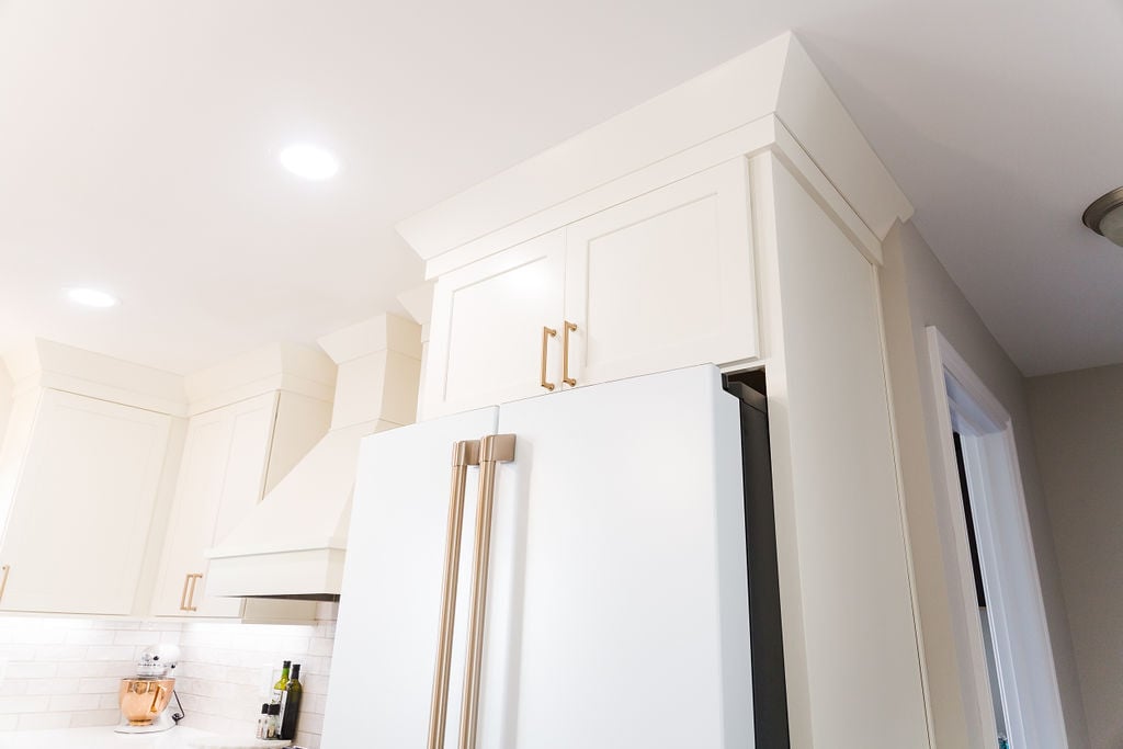 White upper cabinetry and trim detail above refrigerator in a Michigan custom kitchen remodel