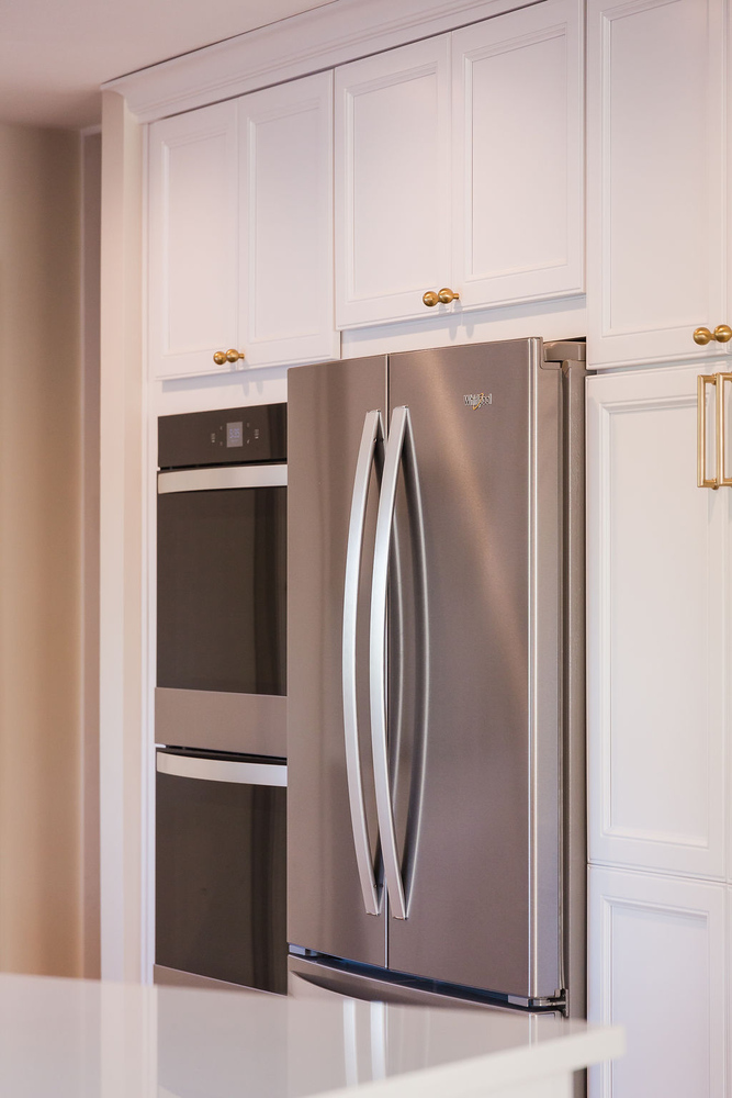 Built-in stainless steel appliances surrounded by custom white cabinetry in a Ferndale kitchen by Cabinet Creations