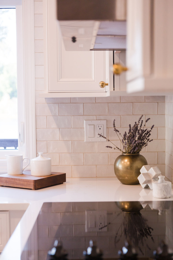 Close-up of custom white kitchen backsplash and gold vase décor by Cabinet Creations in Oakland County, MI