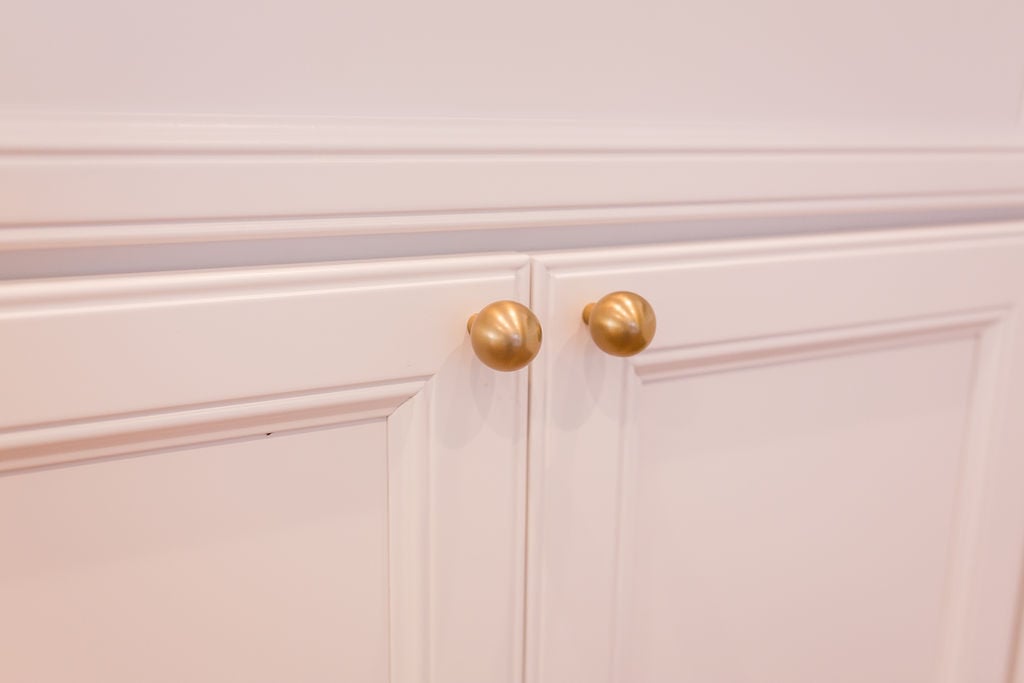 Close-up of elegant gold knobs on white cabinet doors in a custom kitchen by Cabinet Creations, Oakland County, MI