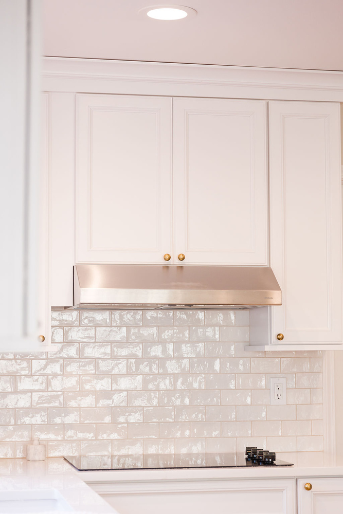Detail view of cooktop and white tile wall in custom Oakland County, MI kitchen by Cabinet Creations