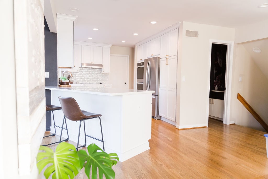 Kitchen peninsula with seating and modern white cabinetry in a custom home by Cabinet Creations, Oakland County, MI