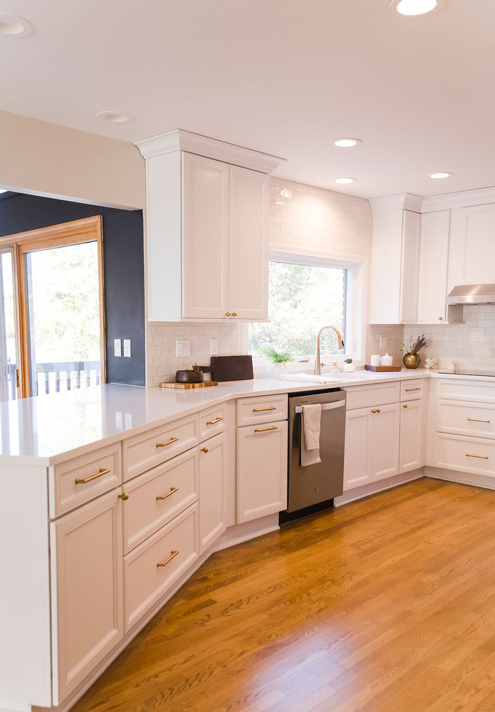 L-shaped white kitchen with quartz countertops and natural wood floors by Cabinet Creations, Oakland County, MI