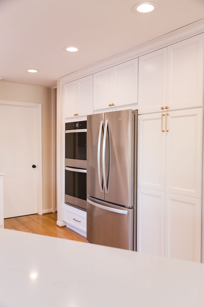 Stainless steel refrigerator and built-in oven wall in custom Waterford, MI kitchen by Cabinet Creations