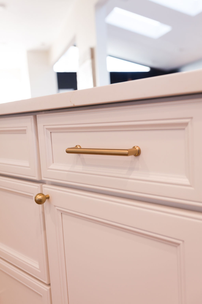 White kitchen drawer with sleek brass pull by Cabinet Creations in an Oakland County custom home
