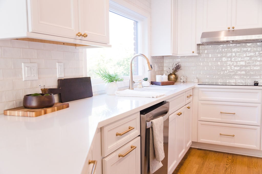 Wide view of white kitchen with brass hardware and corner sink by Cabinet Creations in Oakland County, MI