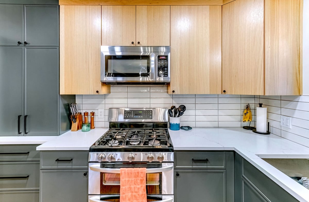 Central view of modern kitchen with pendant lighting and minimalist cabinet hardware in Waterford, MI by Cabinet Creations