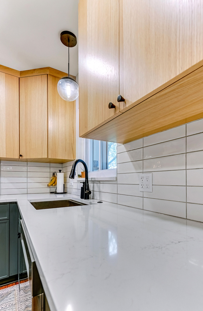 Close-up of kitchen countertop with pendant lighting and modern cabinetry in Waterford, MI by Cabinet Creations