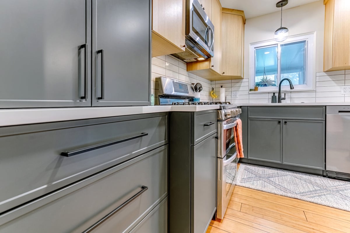 Corner kitchen view with stainless appliances and hardwood flooring by Cabinet Creations in Waterford Township