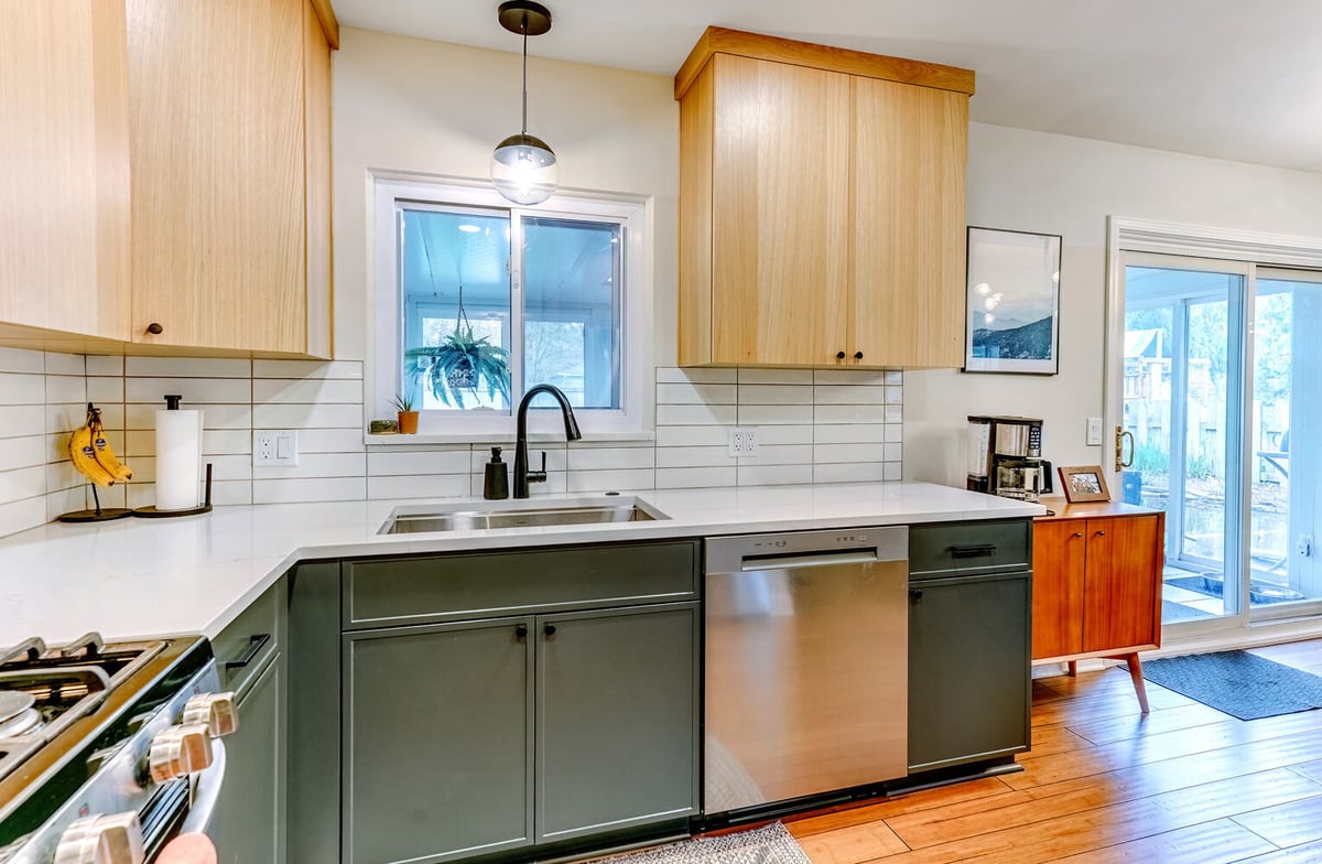 Custom kitchen sink area with large window and natural wood cabinetry in Waterford, MI by Cabinet Creations
