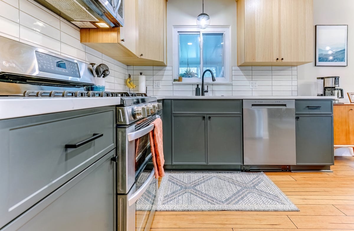 Matte green cabinetry and pendant lighting in Waterford Township kitchen by Cabinet Creations