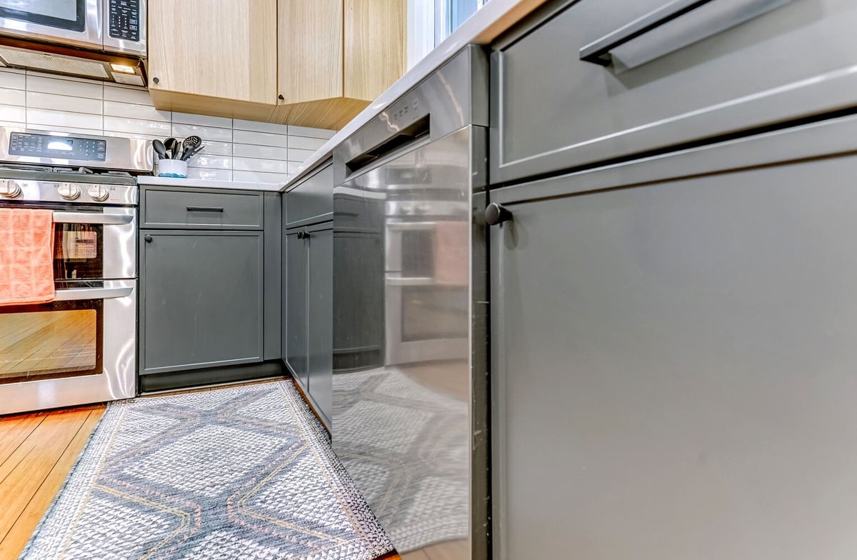 Oakland County kitchen remodel with stainless dishwasher and matte green cabinets by Cabinet Creations