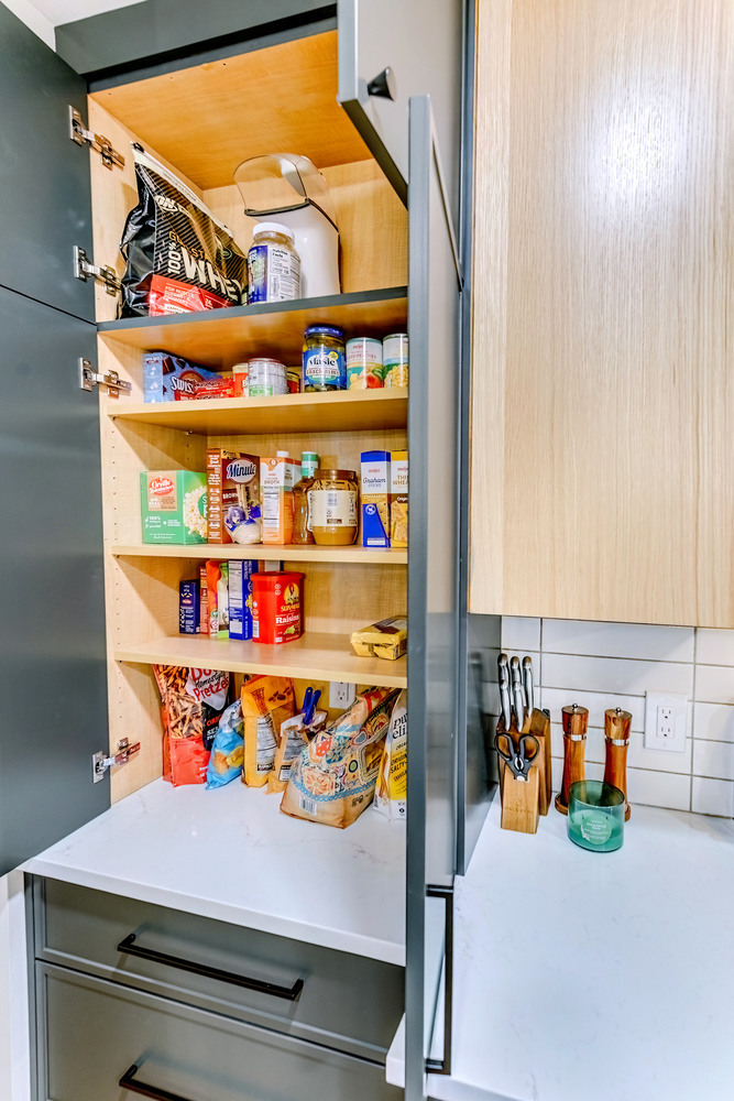 Open pantry cabinet in Waterford Township kitchen remodel by Cabinet Creations showcasing organized food storage