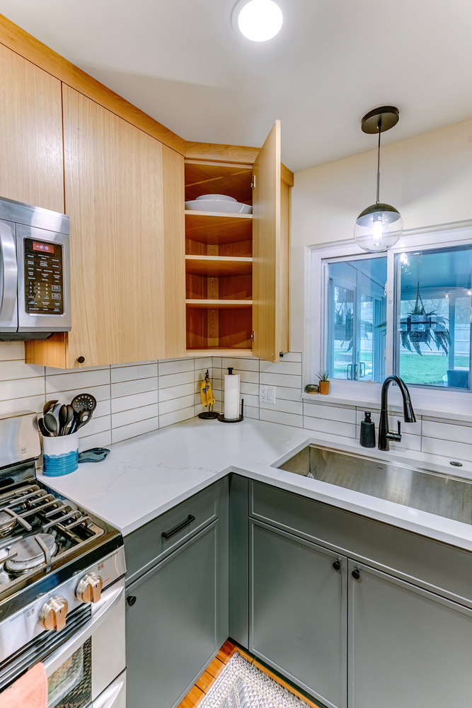 Open upper corner cabinet in Waterford Township custom kitchen by Cabinet Creations with vertical shelf storage